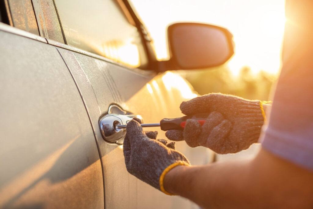 Car technician wearing white gloves and using screwdriver to fix